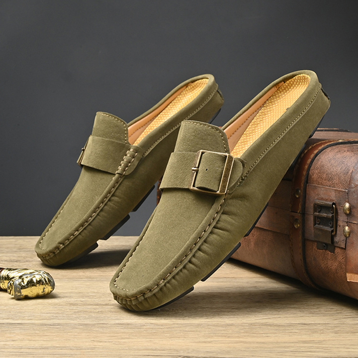 Pair of olive suede loafers with gold buckle strap and low-profile sole