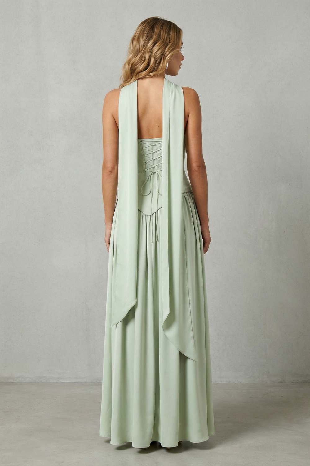 Mint green strapless gown from the back with draped pleated skirt and open back