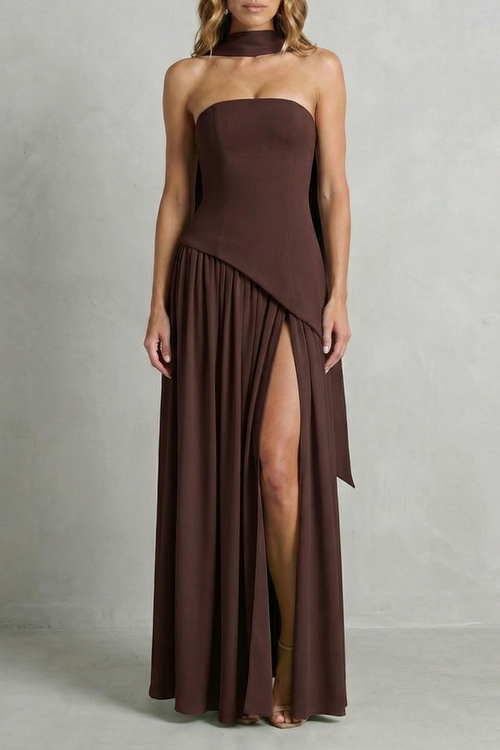 Brown strapless formal gown with asymmetric drape and pleated skirt with high slit