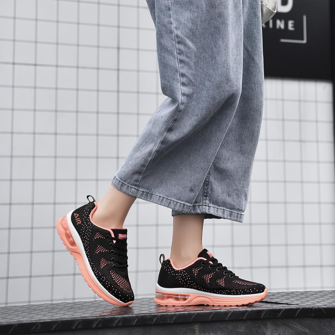 Black and orange cushioned walking sneakers worn with light-wash jeans, lace-up