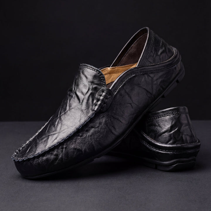 Black leather loafer with moc toe stitching and braided keeper detail