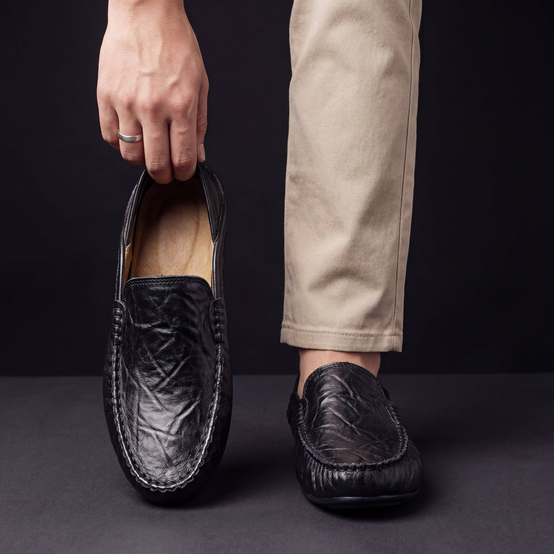Black leather loafer with moc toe stitching, slip-on worn with pants