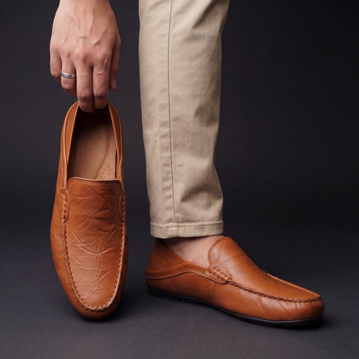 Cognac leather loafer with moc toe stitching, slip-on worn with pants