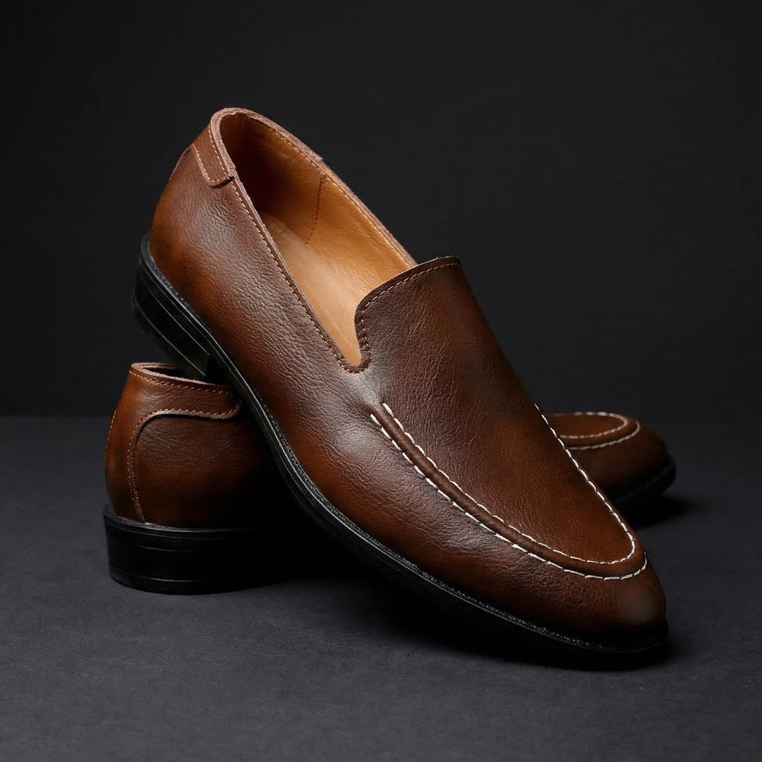 Brown slip-on loafer with rounded toe, stitched apron, and black rubber sole