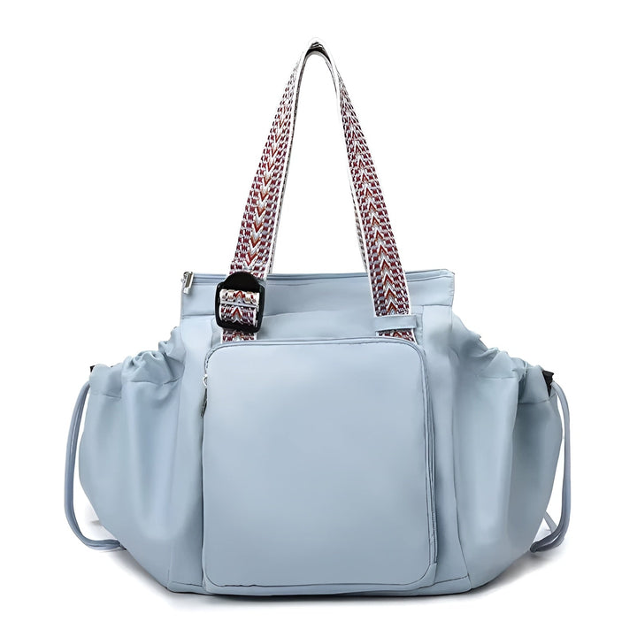 Light blue 3-in-1 organized tote bag with front pocket, ruffled sides, and patterned shoulder straps