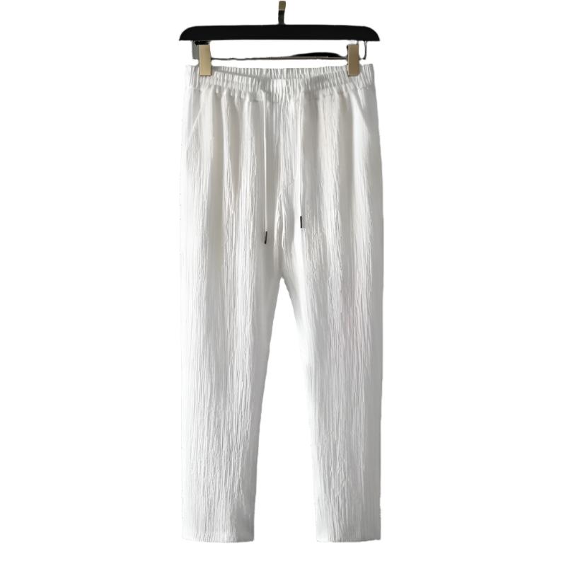 White cotton pants with elastic waistband and drawstring eyelets.