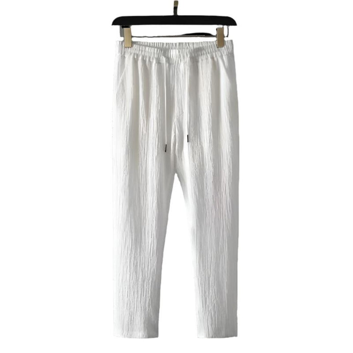 White cotton pants with elastic waistband and drawstring eyelets.
