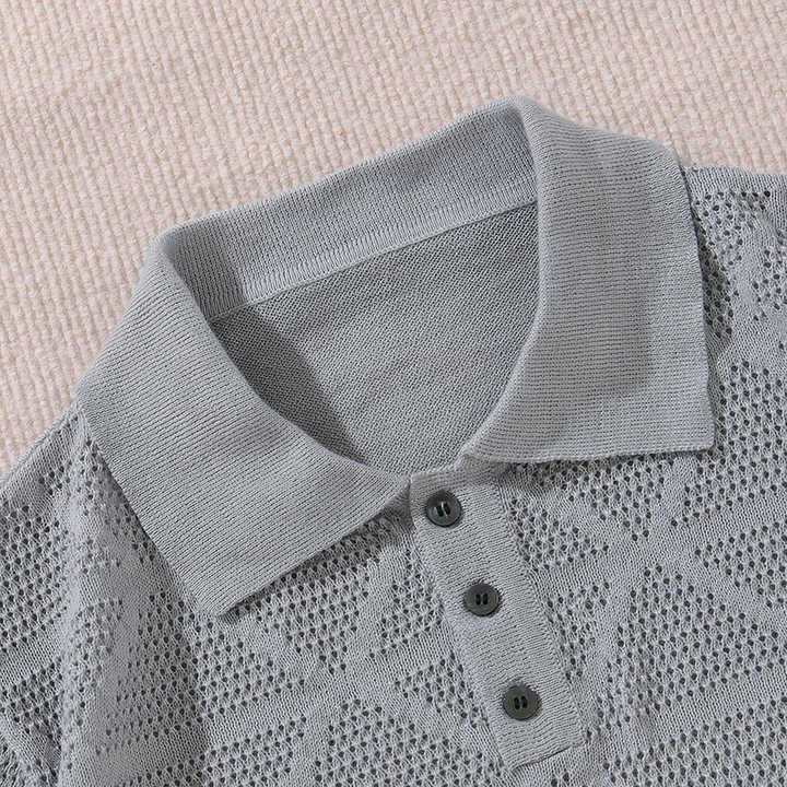 Grey knitted polo close-up with ribbed collar, three dark buttons, and knit texture