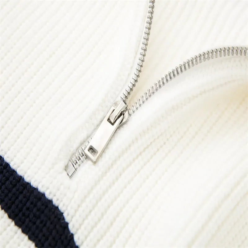 White ribbed knit zipper close-up with metal pull tab