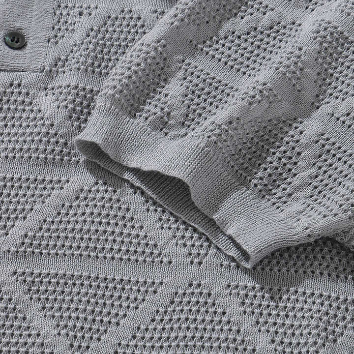 Grey knitted polo knit pattern close-up with ribbed sleeve cuff and placket