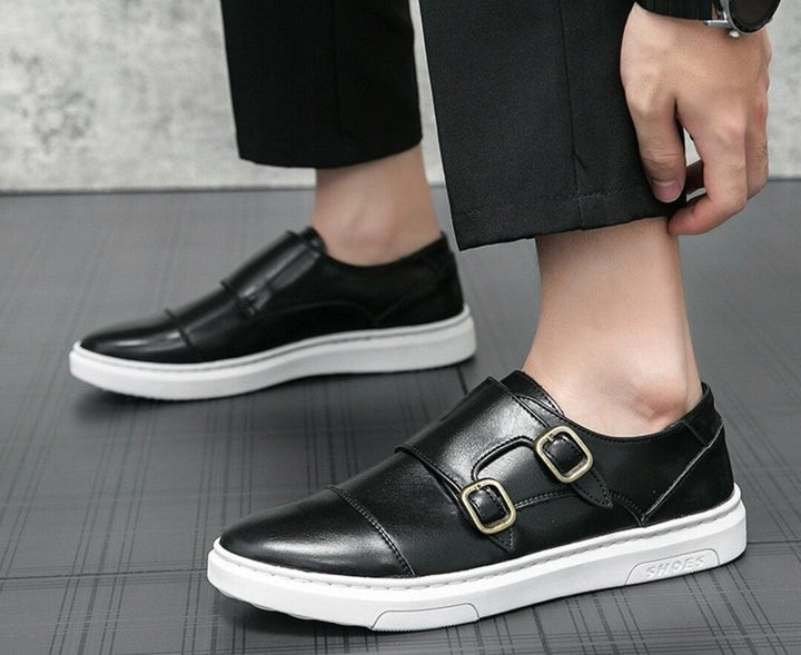 Black strap sneakers on foot with double buckle straps and white sole