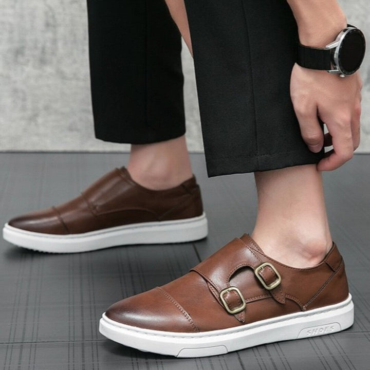 Brown strap sneakers on foot with double buckle straps and white rubber sole