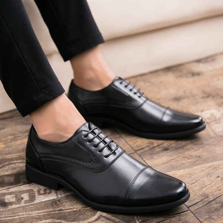 Black leather oxford shoes with lace-up front and wingtip-style side panels