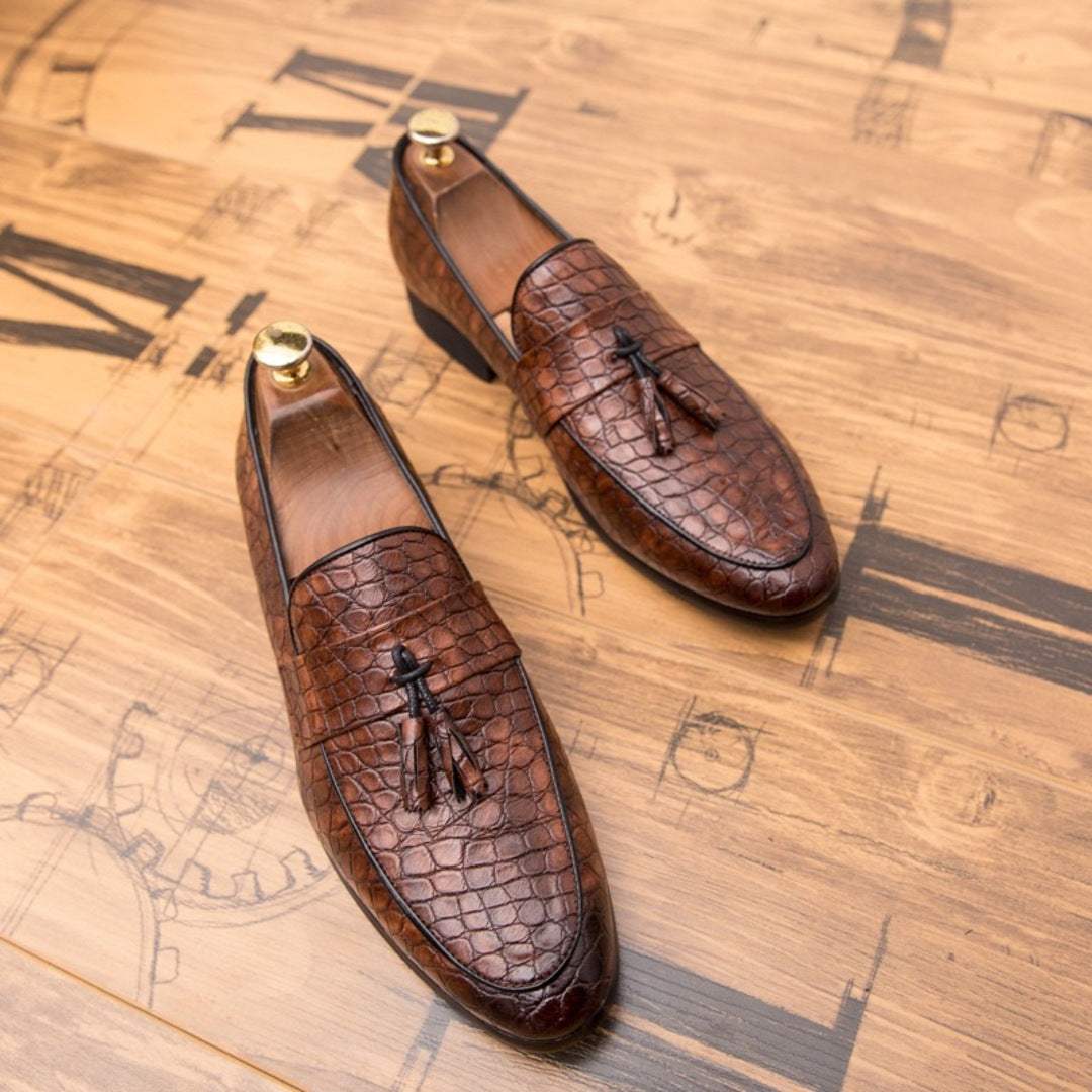 Brown croc loafers with tassel detail and metal heel tabs, side view