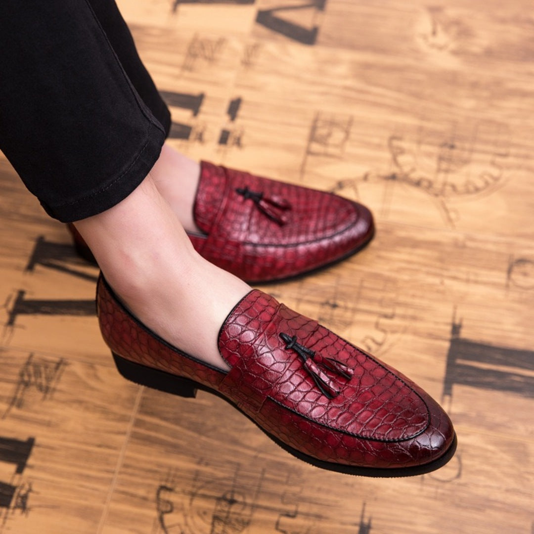 Red croc loafers with tassel detail, worn slip-on style