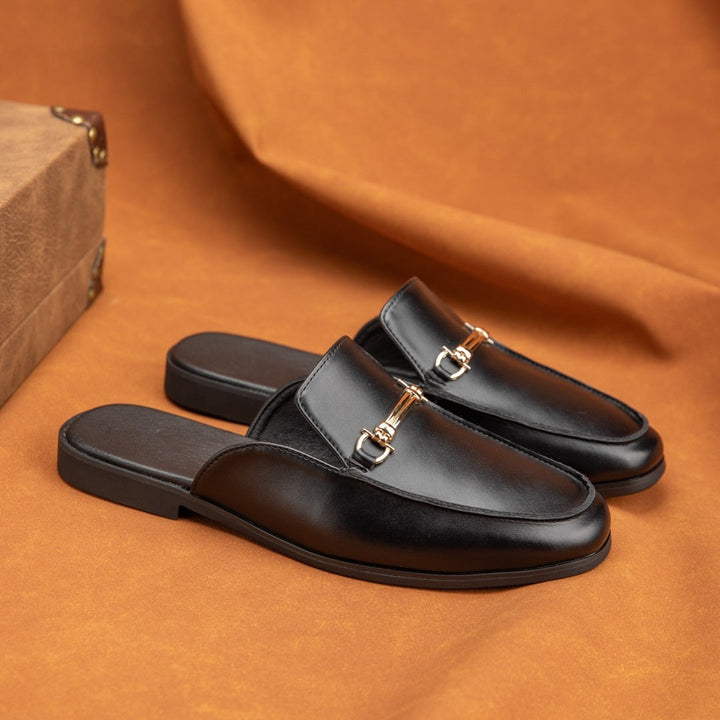 Black leather slip-on sandals with gold-tone buckle detail