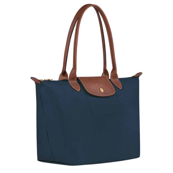 Navy Le Pliage tote with tan leather handles, structured bottom, and snap-front pocket
