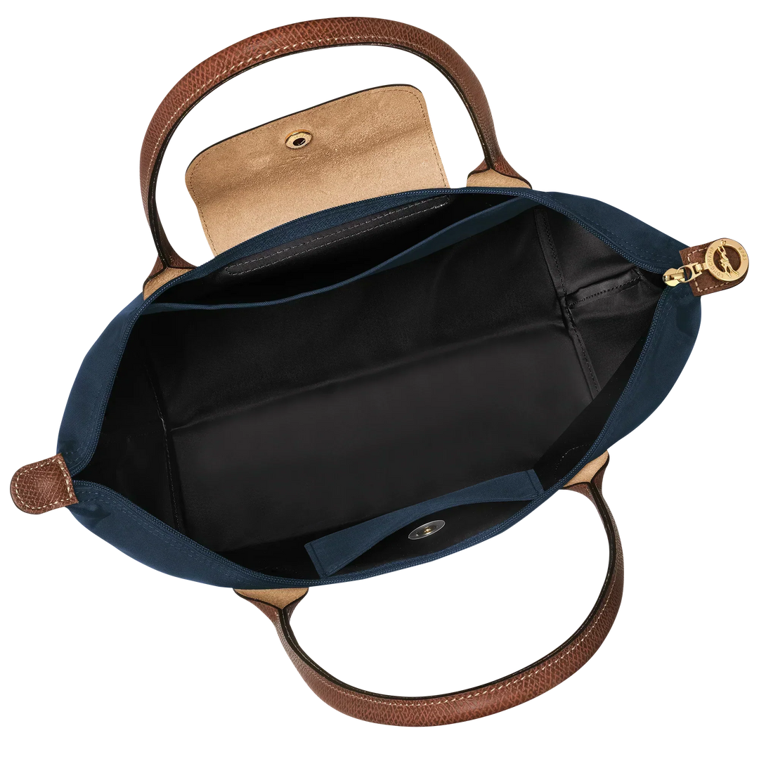 Le Pliage tote interior with black lining, open slip pocket, and zipper-top closure