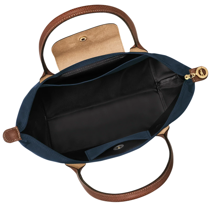 Le Pliage tote interior with black lining, open slip pocket, and zipper-top closure