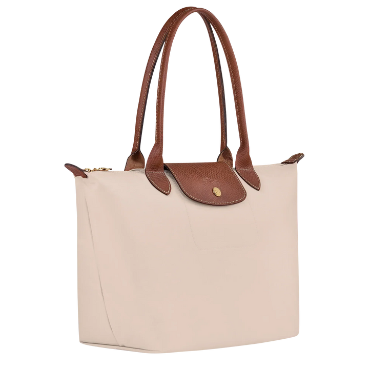 Medium Le Pliage tote angled view in paper canvas with brown leather flap and gold logo