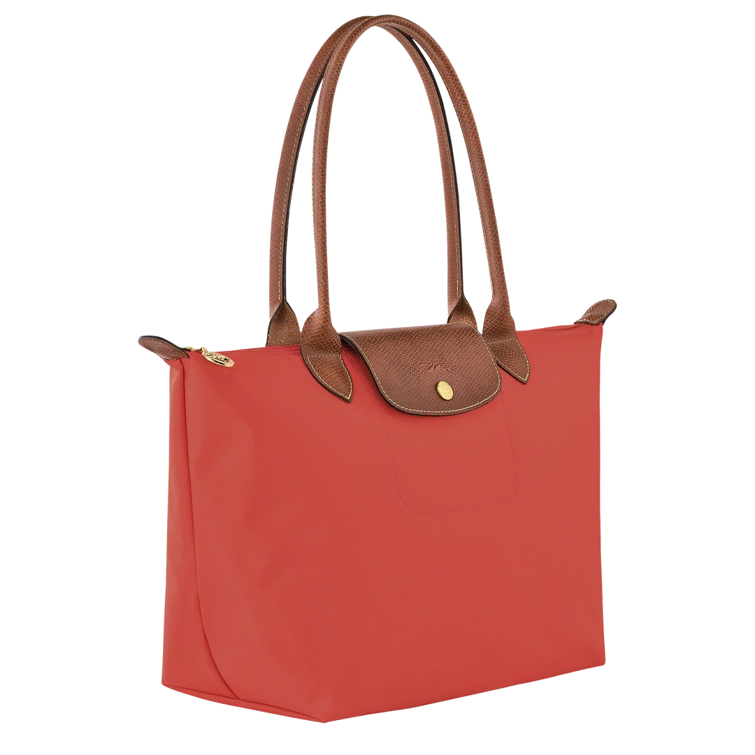 Tomato red medium tote with brown leather handles and front flap pocket with gold snap