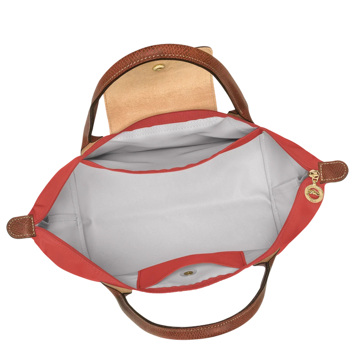 Open tomato red tote showing gray interior lining, inner pocket and brown leather handles