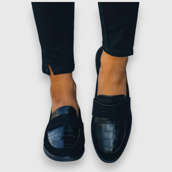 Black penny loafers, top view on feet with cushioned moccasin sole
