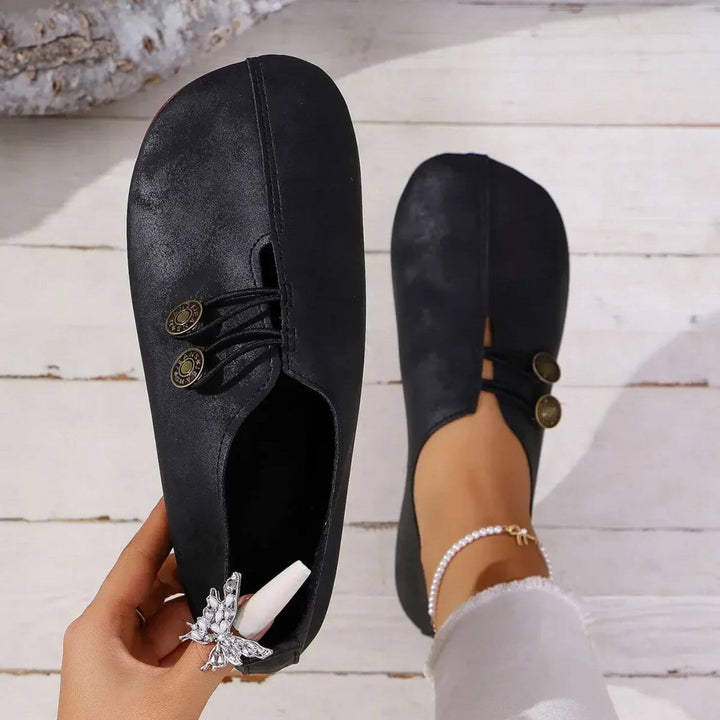 Black button slip-on flats with lace-up vamp and decorative button detail