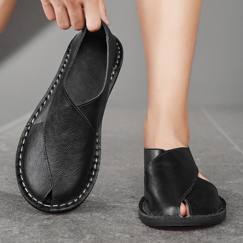 Black leather open-toe sandals worn with ankle-length socks, stitched side panels