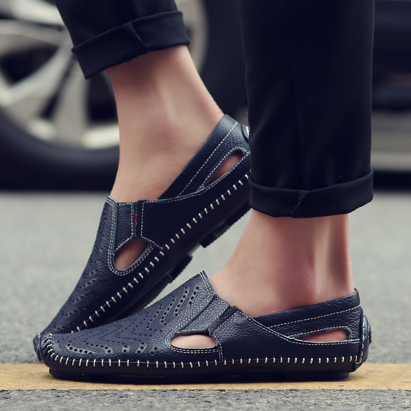 Navy perforated slip-on sandals worn with ankle-length pants, stitched edges