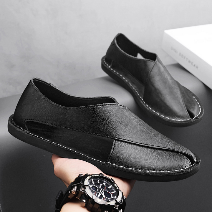 Black leather sandals with stitched upper and low sole, side angle view