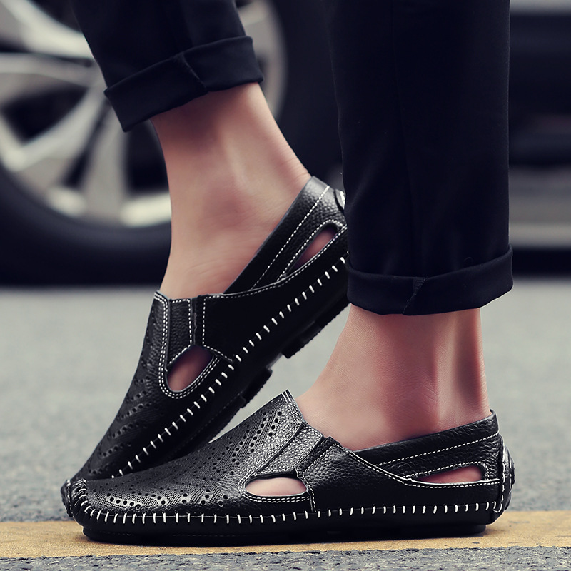 Black slip-on sandals with perforated design, orange accents, and top strap detail