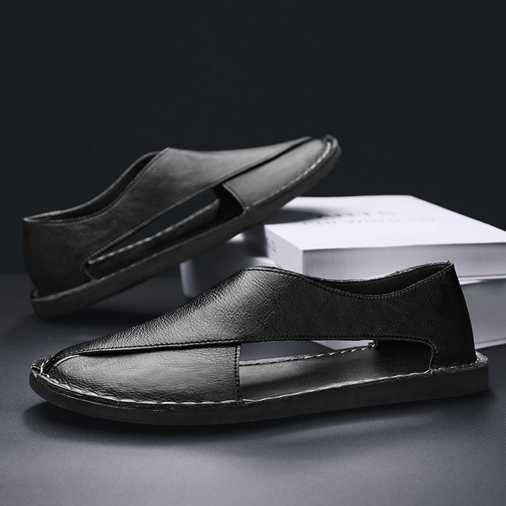 Black leather slide sandals with stitched strap and open-toe cutout