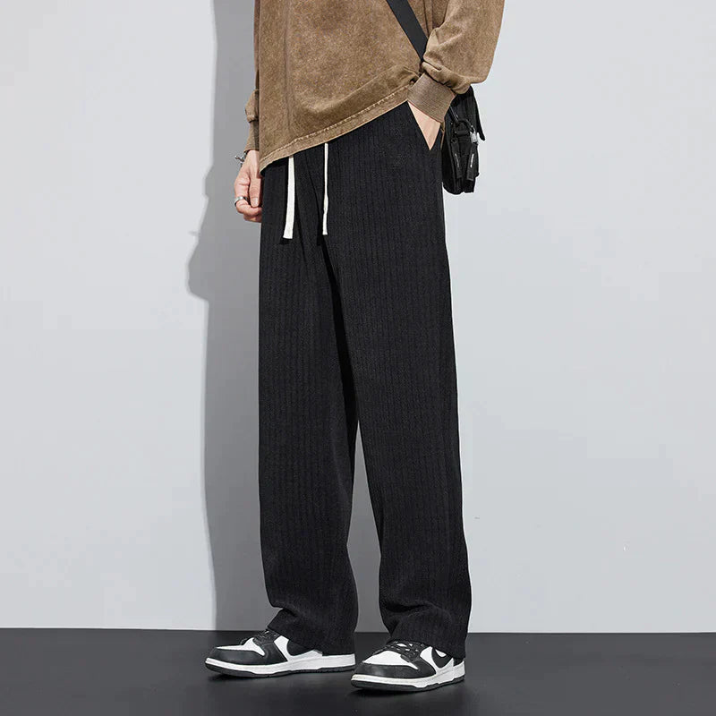 Black Roman velvet pants with elastic waistband and drawstring ties, straight wide-leg silhouette.