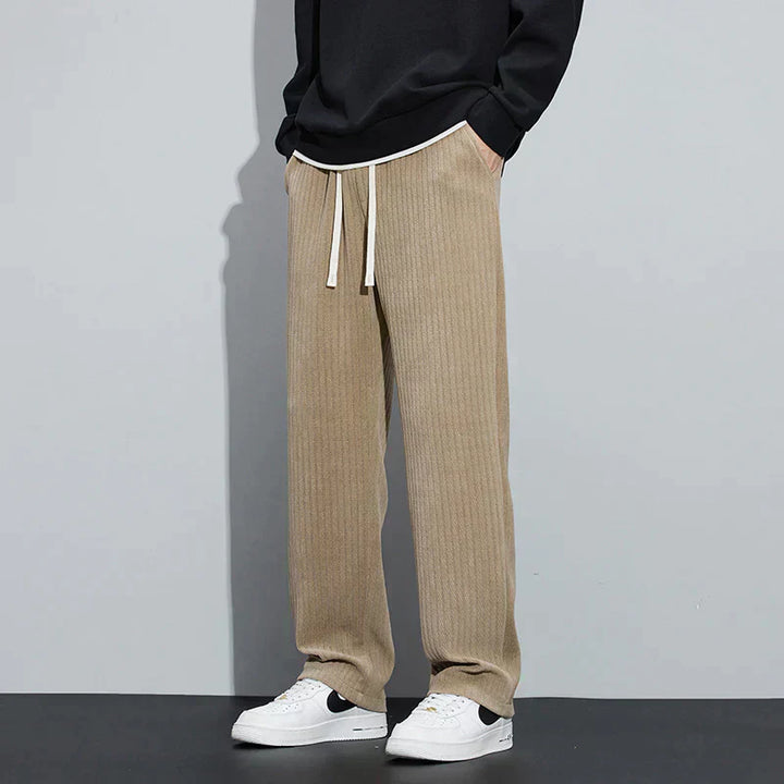 Nude Roman velvet pants with elastic waistband and drawstring ties, relaxed wide-leg style.