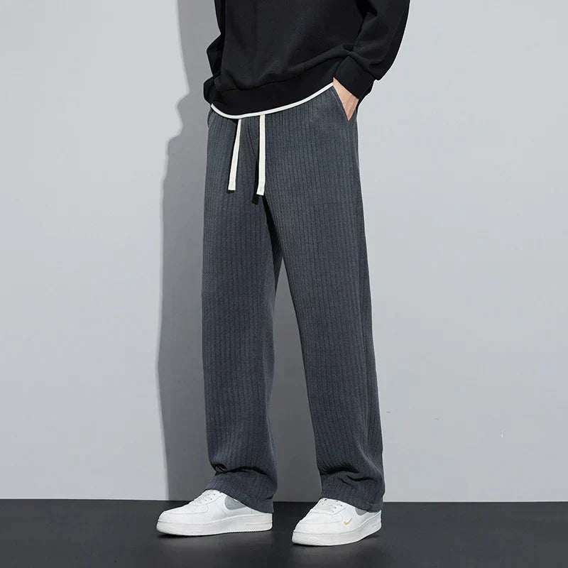 Dark gray Roman velvet pants with elastic waistband and drawstring ties, relaxed wide-leg fit.
