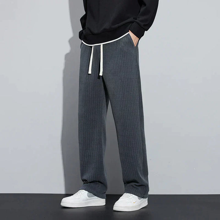 Dark gray Roman velvet pants with elastic waistband and drawstring ties, relaxed wide-leg fit.