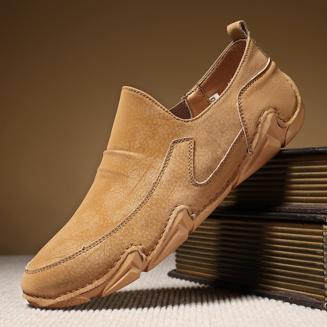 Tan slip-on loafers with moc-toe stitching and thick rubber tread sole.