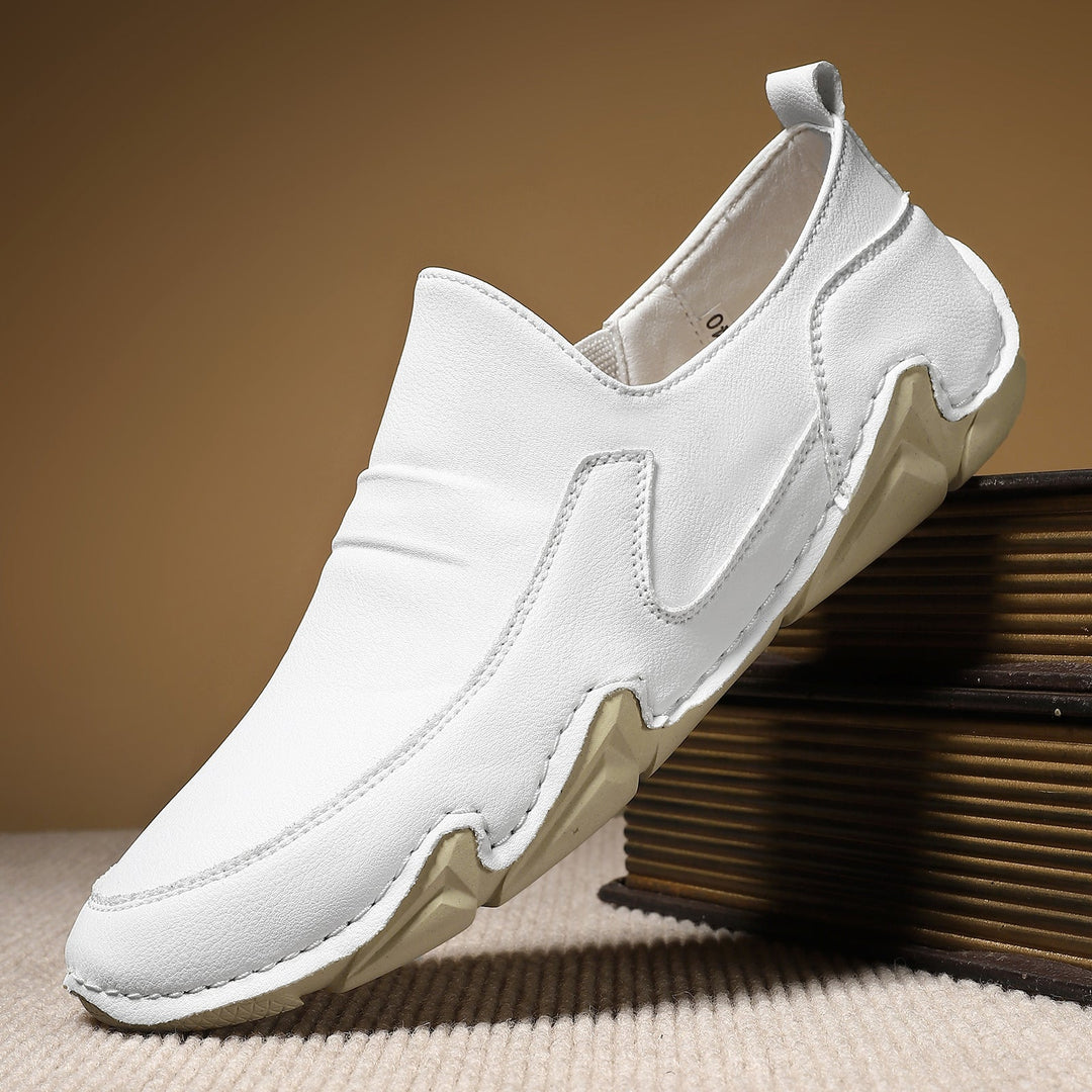 White slip-on loafers with moc-toe stitching and thick cushioned rubber sole.