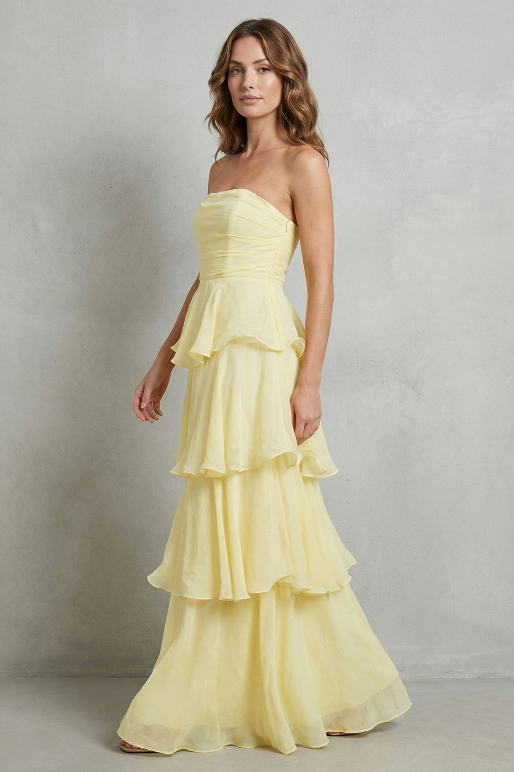 Light yellow strapless tiered maxi dress with layered ruffle skirt, side view