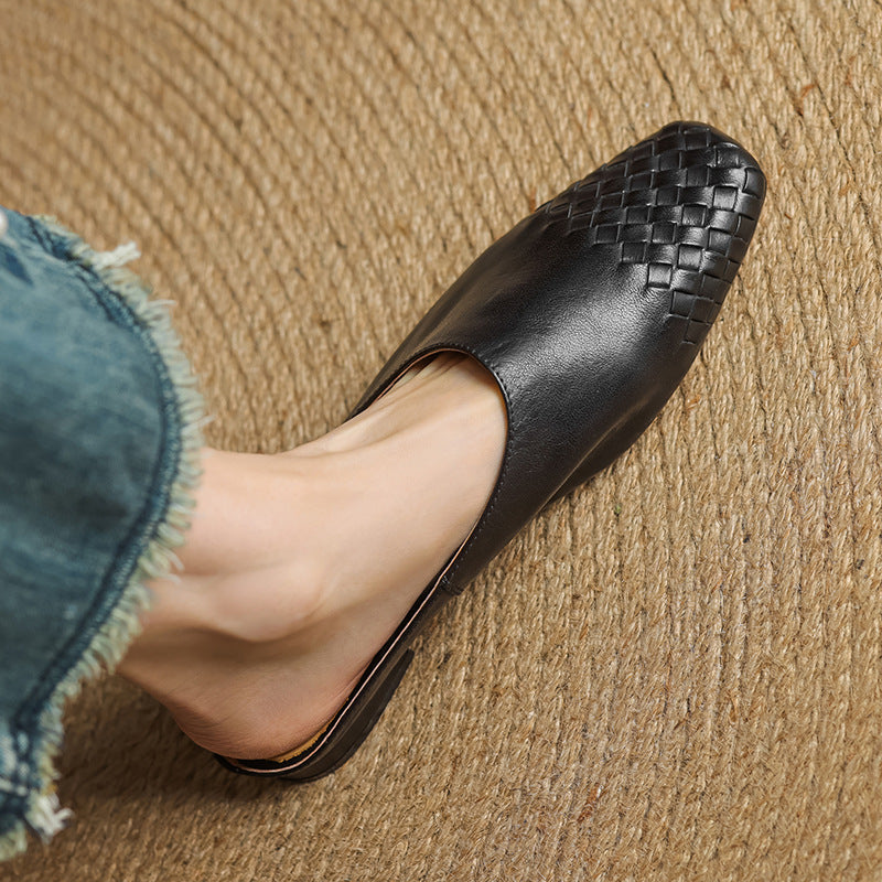 Black woven flat mule with pointed toe and crisscross upper detail