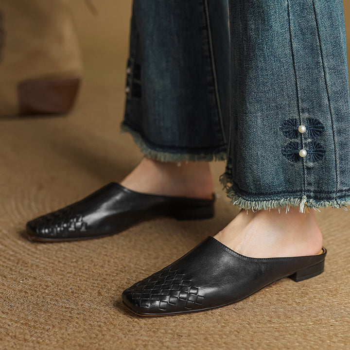 Black woven flat mules with pointed toe, low profile and slip-on fit