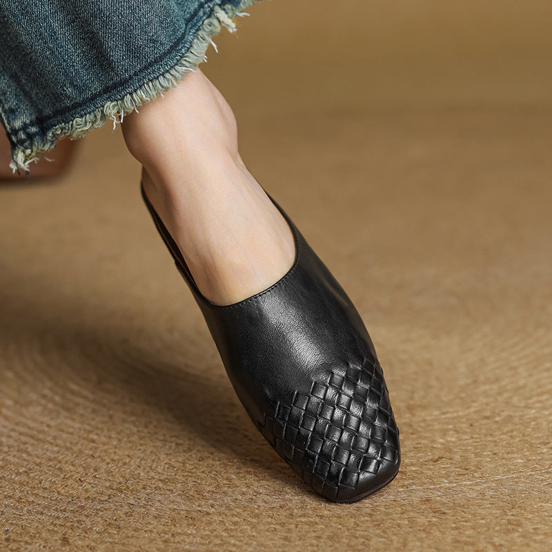 Black woven flat mule side view with pointed toe and low profile