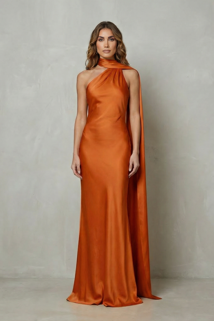 Orange satin mermaid gown with sleeveless halter neckline and long flowing side drape