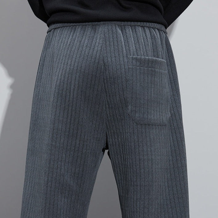 Charcoal Roman velvet pants close-up, wide-leg cut with textured fabric and side seam.