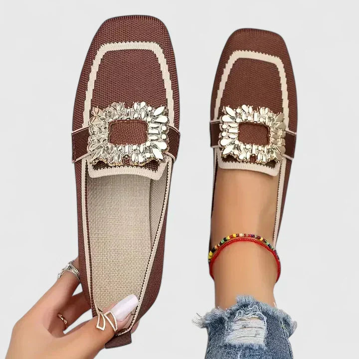 Brown square-toe flats with white trim and ornate gold jeweled buckle