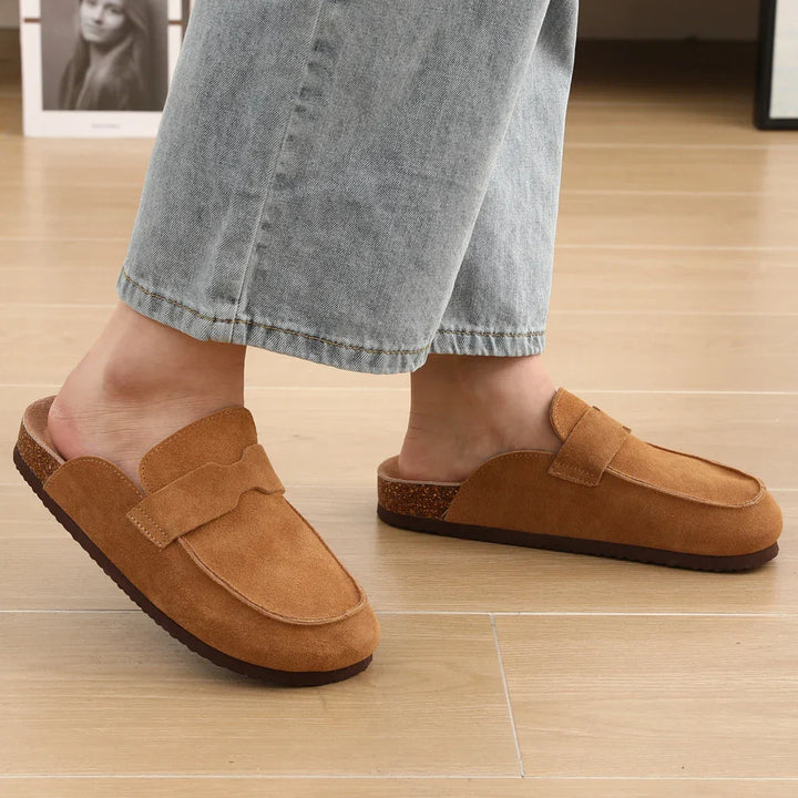 Tan suede penny mule worn with rolled jeans, strap and rubber sole