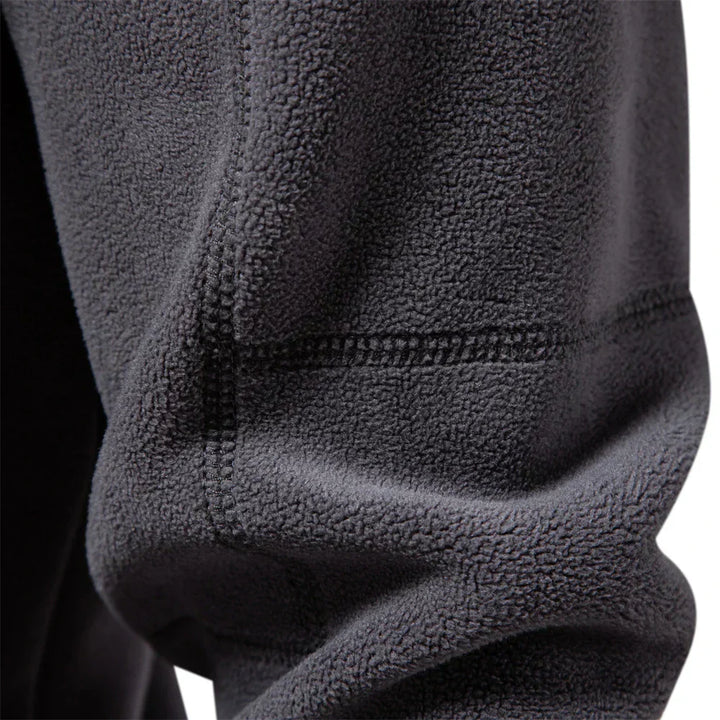 Dark gray fleece windbreaker jacket detail, textured fabric and stitched half-zip collar