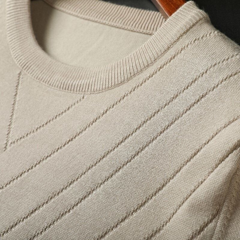 Beige cashmere knit close-up with ribbed crew collar and diagonal stitch lines