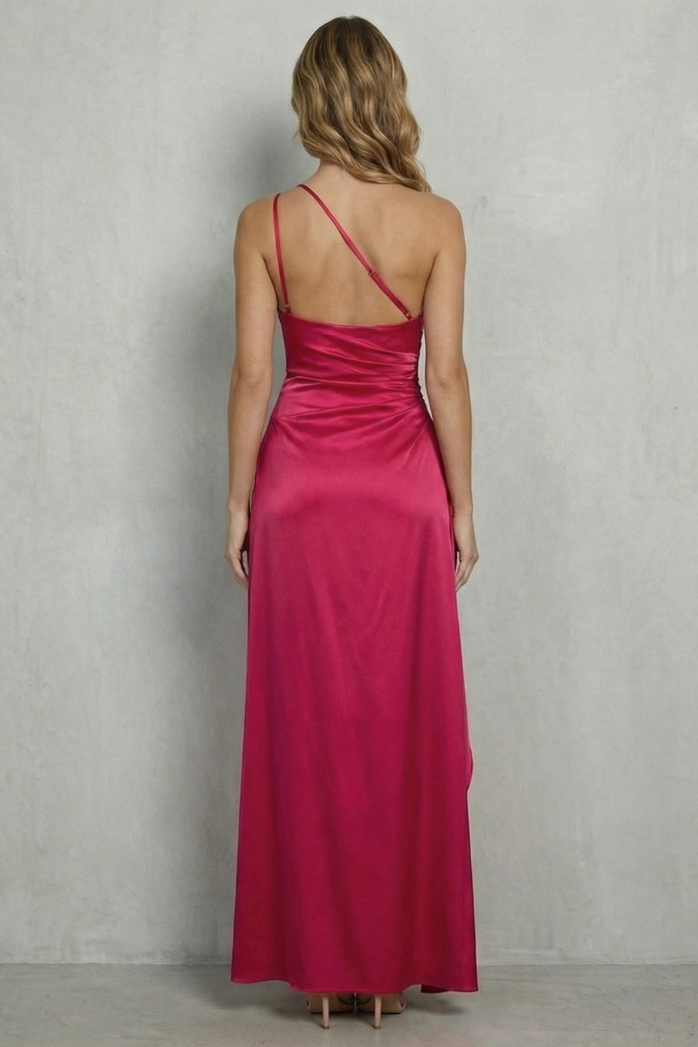 Hot pink one-shoulder gown back view with thin straps and long skirt slit